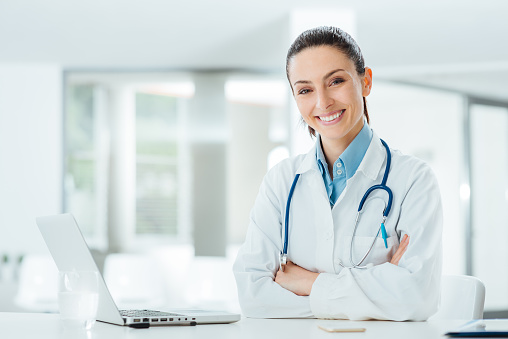 Confident female doctor at office desk